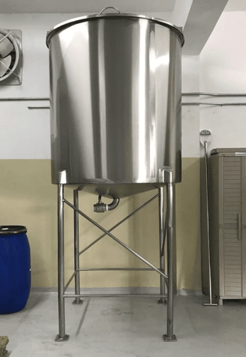 Tanque cilíndrico de acero inoxidable elevado sobre una estructura metálica con fondo cónico.